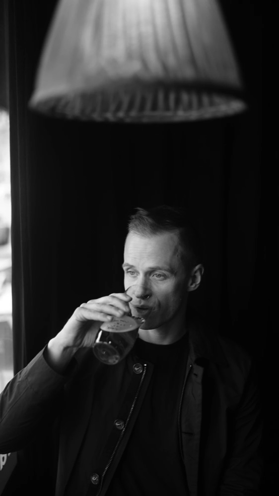 Black and white photo of Mattias having a drink