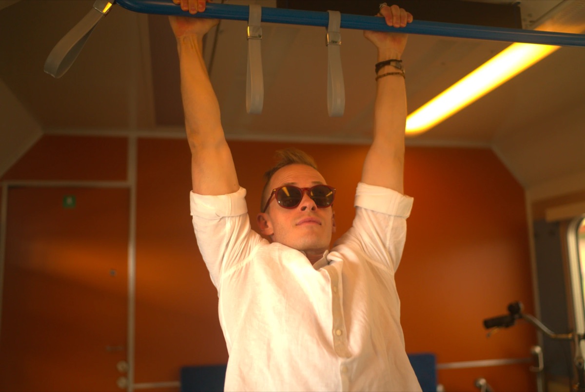 Mattias hanging from a bar on a train
